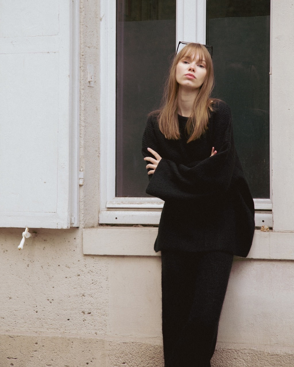 woman wearing a black outfit standing by a window