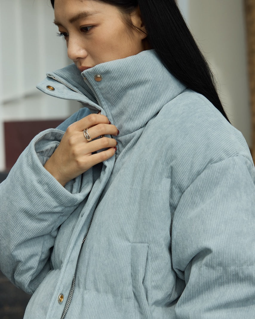 woman wearing a light blue corduroy jacket with a blurred background