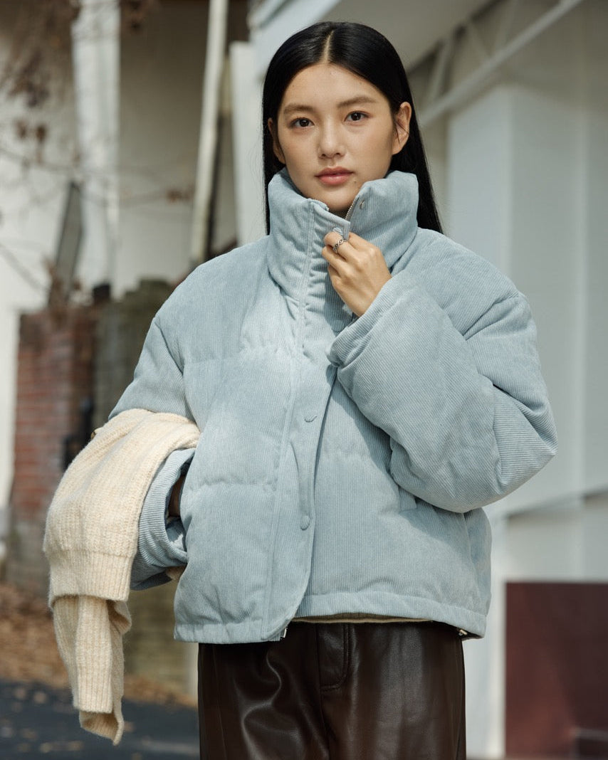 Woman wearing a light blue puffer jacket outdoors