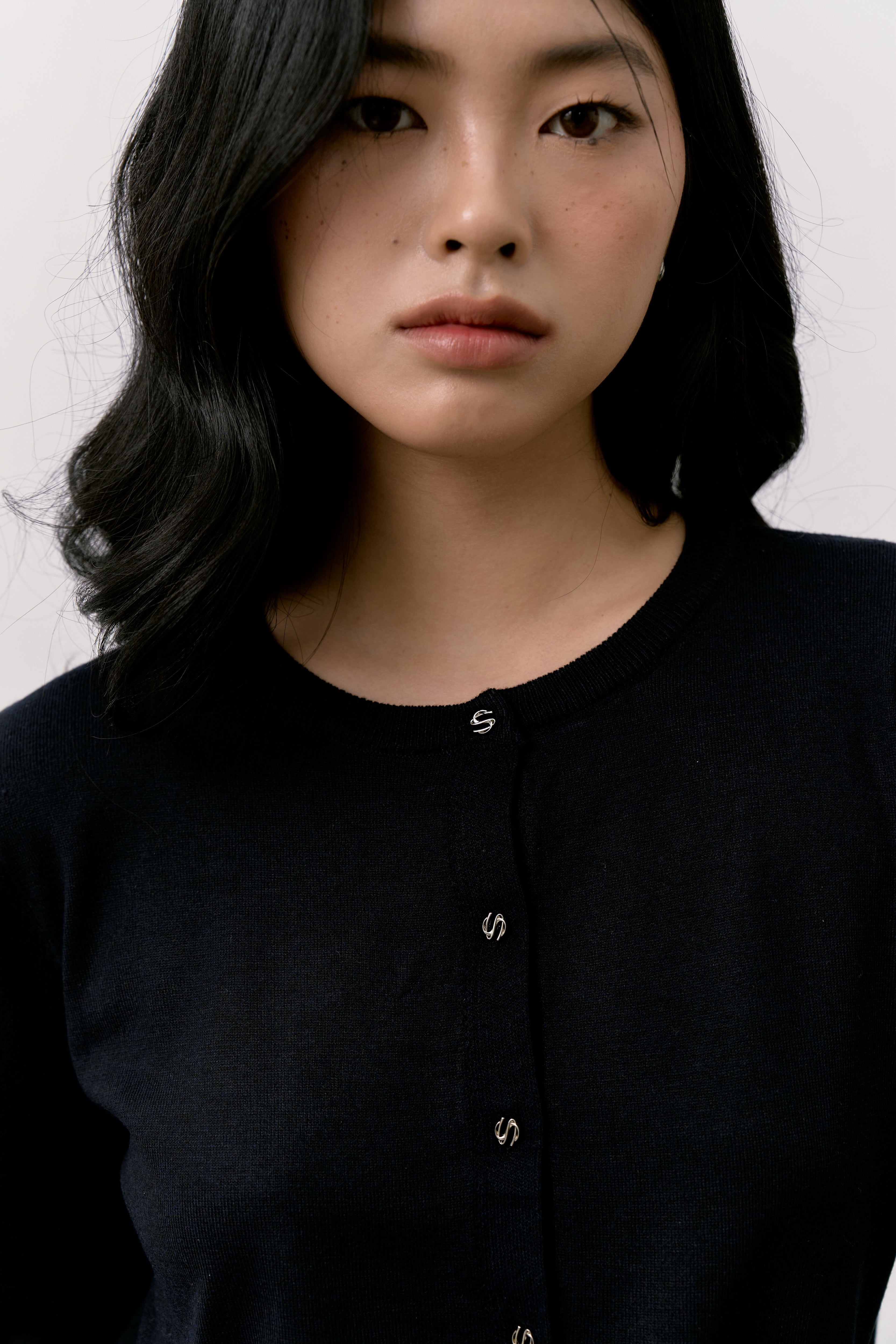 Woman wearing a black shirt against a white background.