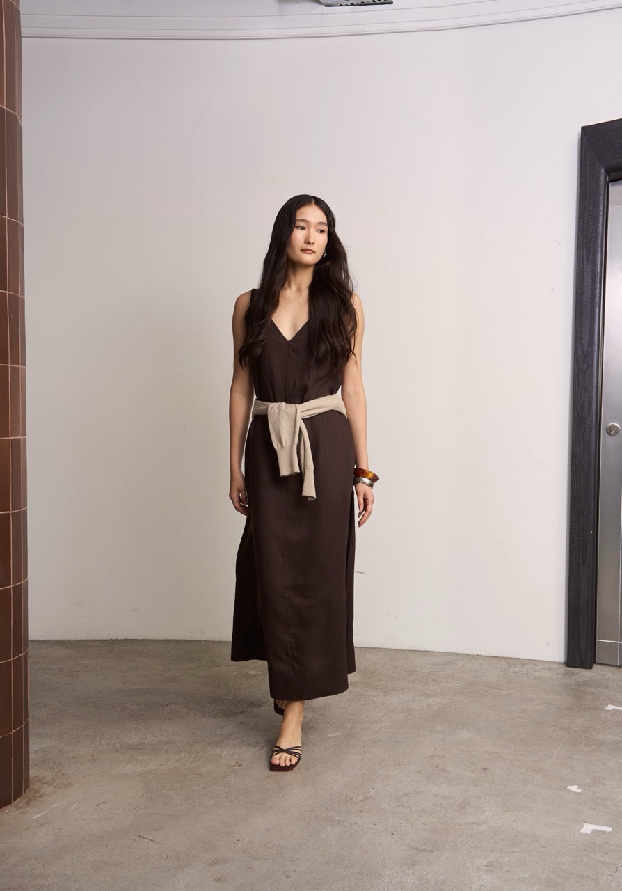 Woman wearing a brown linen dress with a beige styling in an indoor setting