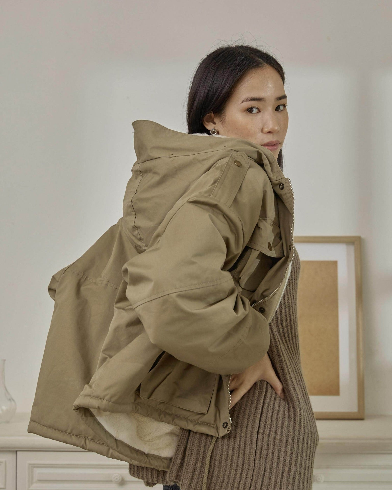Woman wearing a beige jacket in an indoor setting
