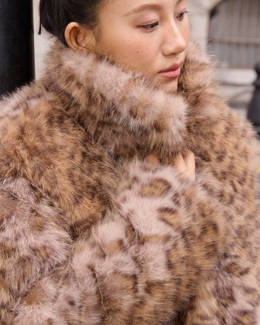 woman wearing a fur coat with a blurred background