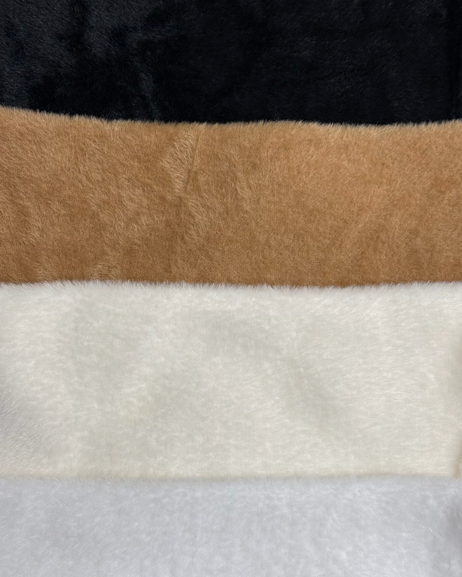Close-up of fabric with black, brown, white, and gray stripes.