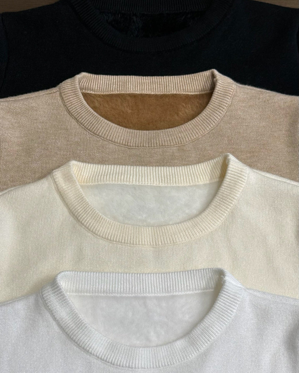 Three Mink Sweater in black, beige, and white arranged in a row.