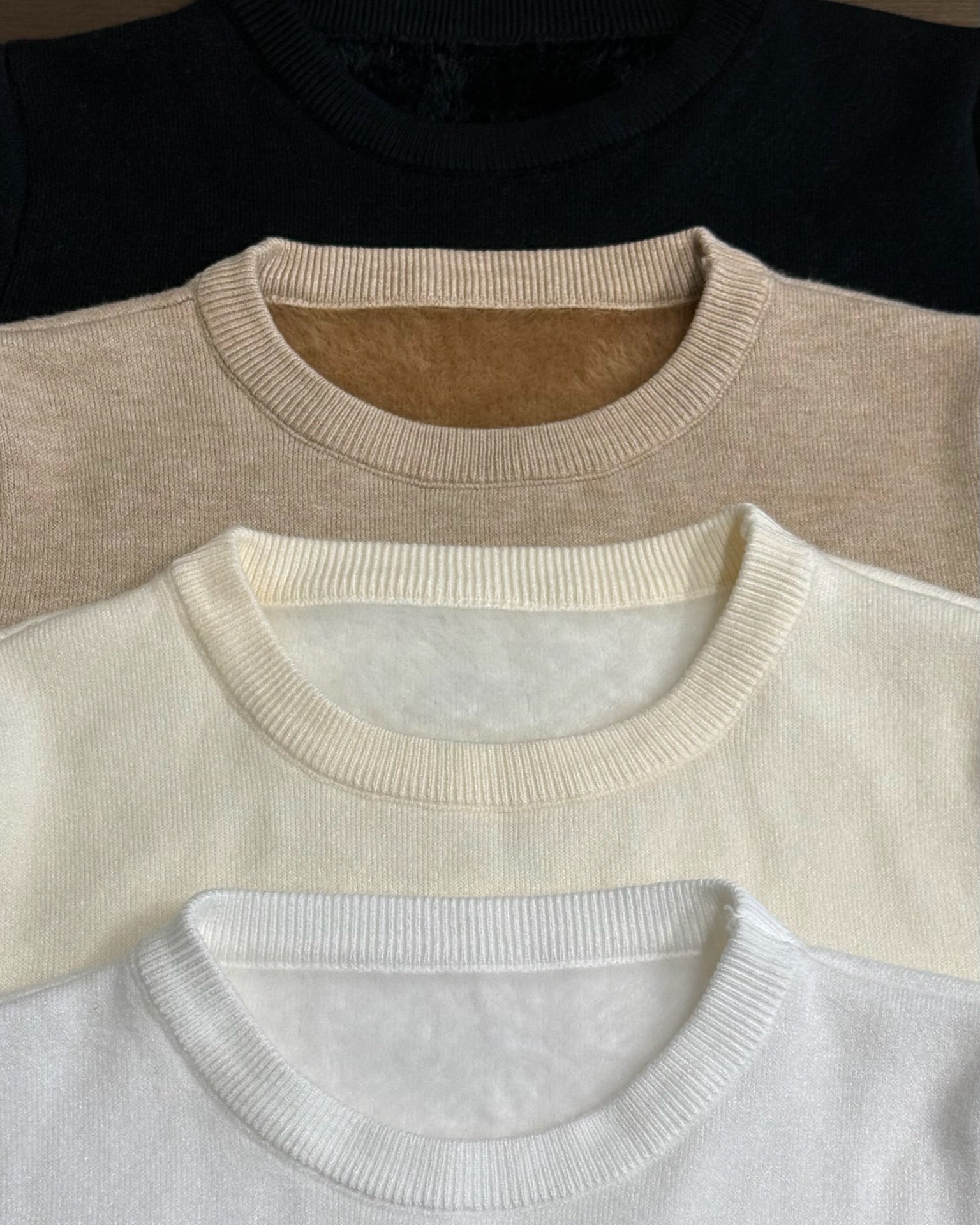 Three Mink Sweater in black, beige, and white arranged in a row.