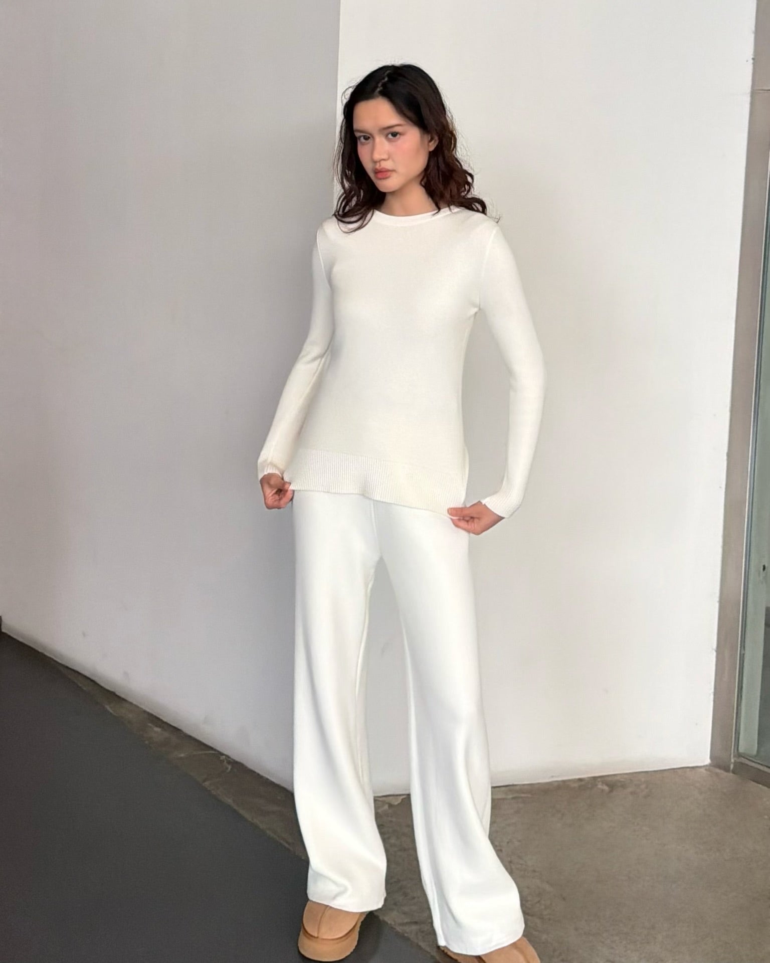 Woman wearing a white outfit against a plain background