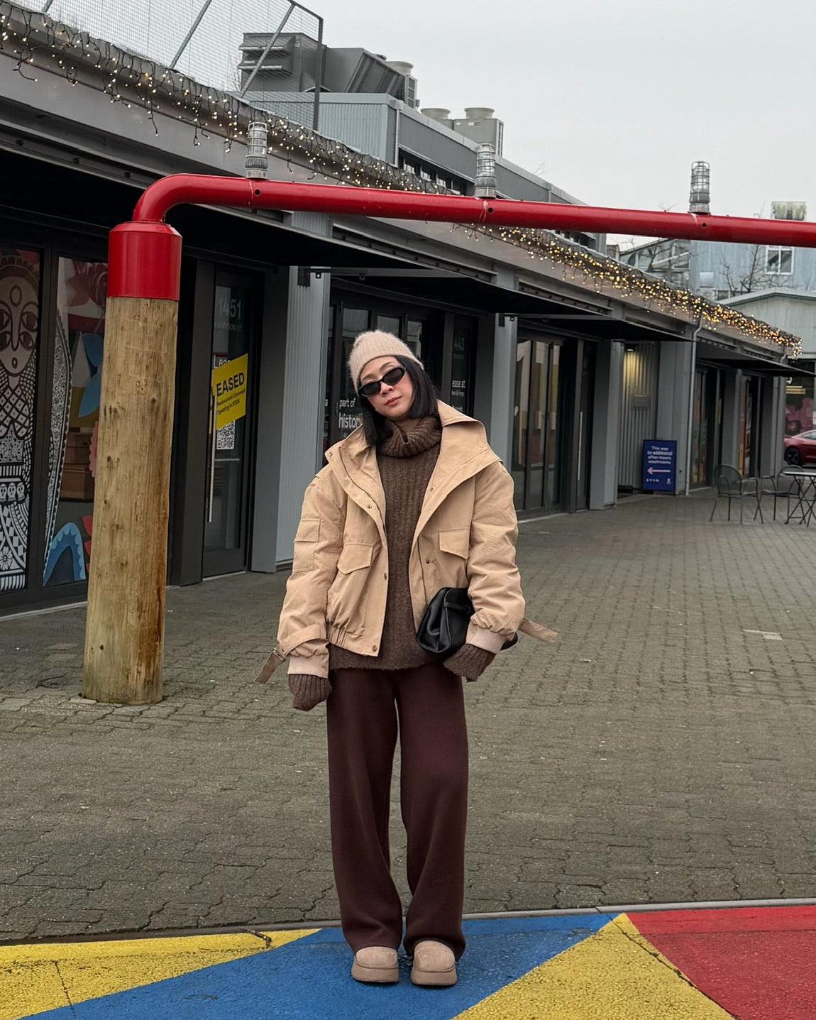 Person standing on a colorful pavement with industrial structure in the background