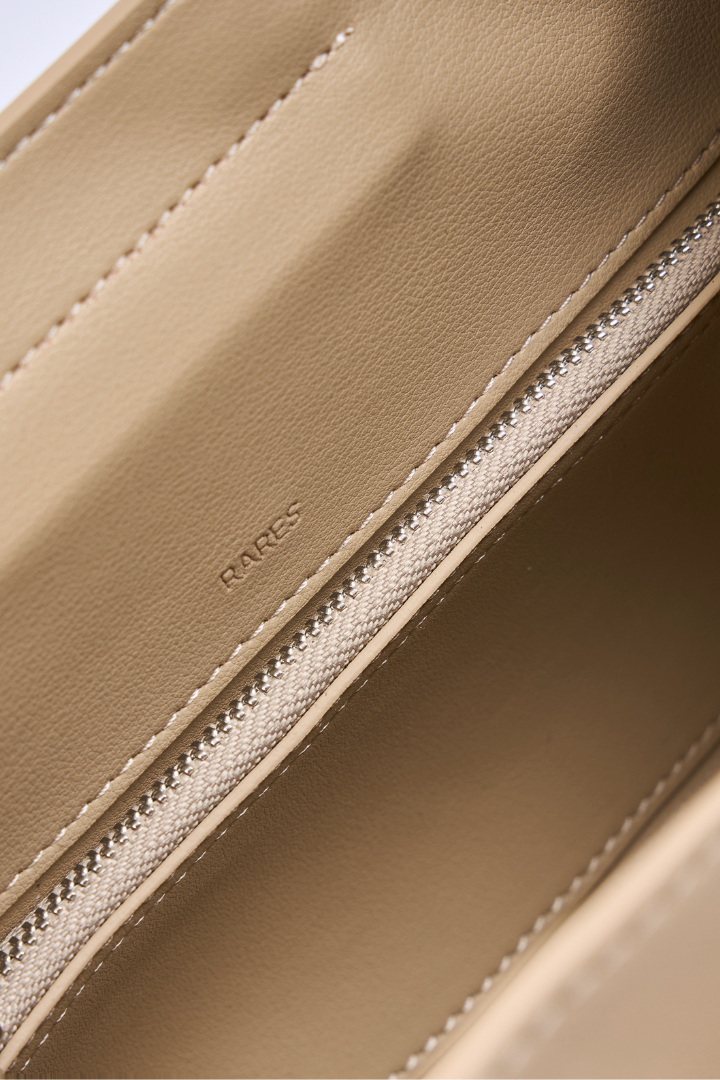 Close-up of a beige leather interior showing a zipper with white stitching and the debossed brand name 'RARES'.