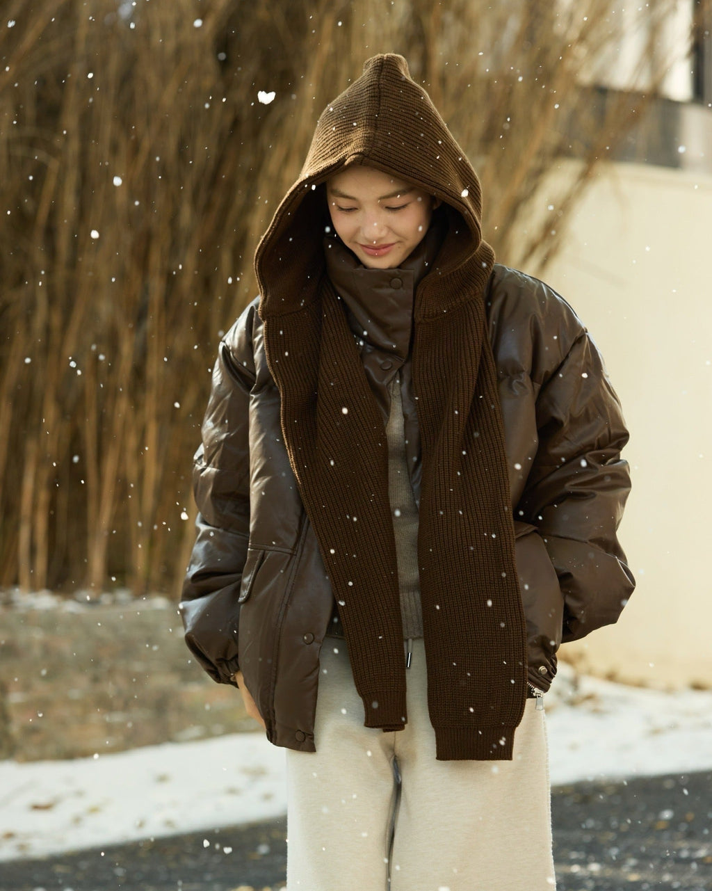 woman wearing a brown hooded coat in a snowy outdoor setting