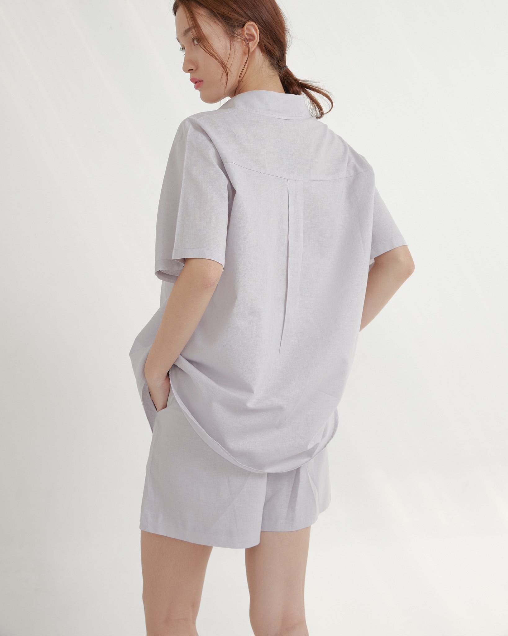 Woman wearing a Taro oversized shirt on a white background