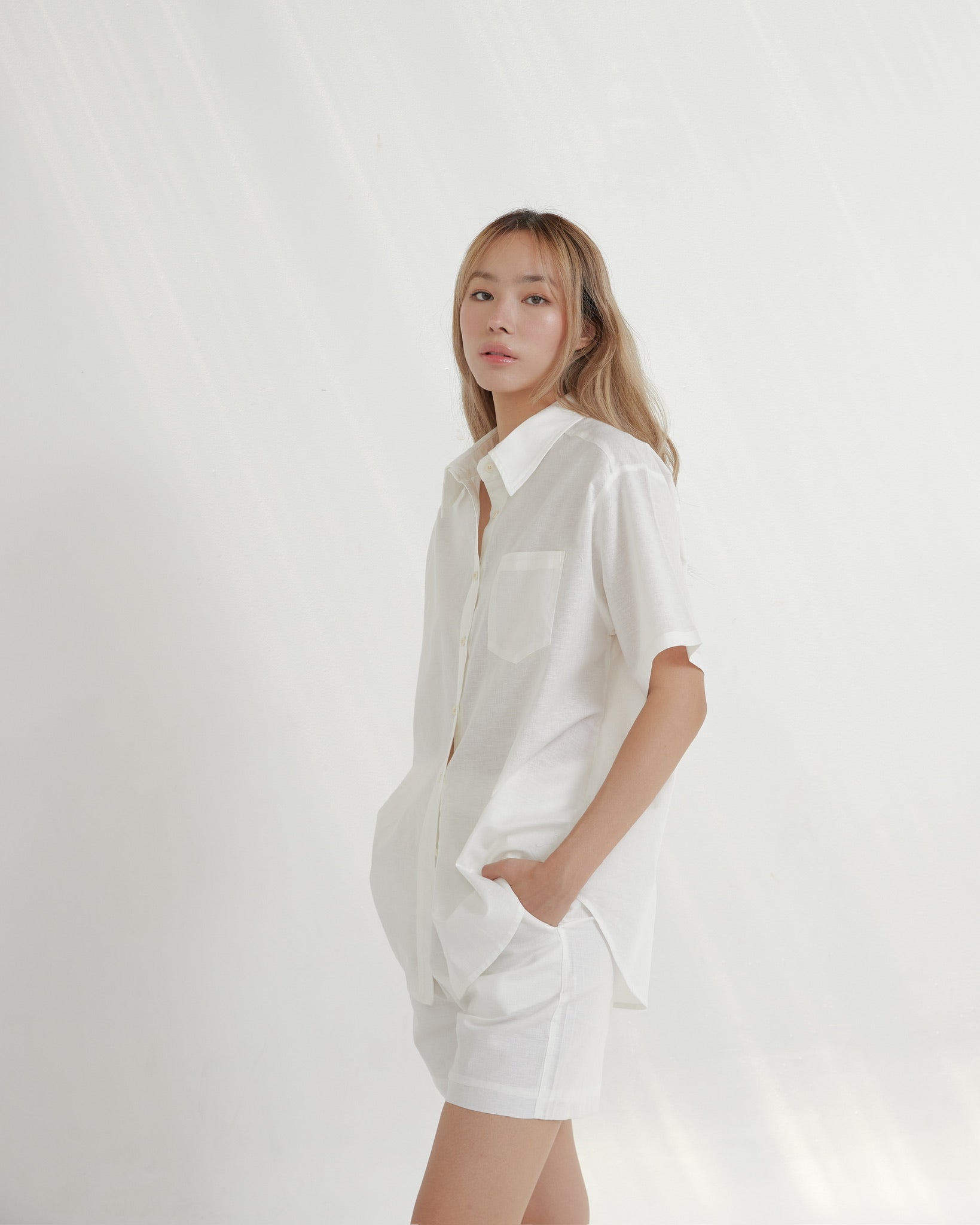 Woman wearing a white shirt against a plain background